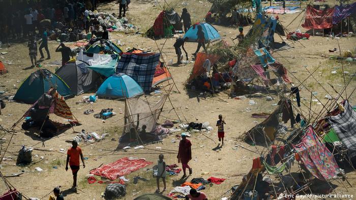 Menschen in einem Lager aus Zelten und improvisierten Notunterkünfte auf staubigem Boden