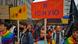 Pride parade attendees hold up banners Pride parade attendees hold up banners