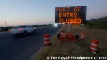 A neon sign on the US border that reads 'Port of Entry closed'