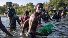 CIUDAD ACUNA, MEXICO - SEPTEMBER 20: A Haitian immigrant glances back towards the United States while crossing the Rio Grande back into Mexico from Del Rio, Texas on September 20, 2021 to Ciudad Acuna, Mexico. As U.S. immigration authorities began deporting immigrants back to Haiti from Del Rio, thousands more waited in a camp under an international bridge in Del Rio and others crossed the river back into Mexico to avoid deportation. (Photo by John Moore/Getty Images)