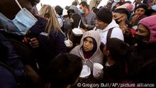 FILE - In this Friday, Feb. 19, 2021, file photo, asylum seekers receive food as they wait for news of policy changes at the border, in Tijuana, Mexico. A federal appellate court refused late Thursday, Aug. 19 to delay implementation of a judgeâ€™s order reinstating a Trump administration policy forcing thousands to wait in Mexico while seeking asylum in the U.S. President Joe Biden had suspended former President Donald Trumpâ€™s â€œRemain in Mexicoâ€ policy on his first day in office and the Department of Homeland Security said it was permanently terminating the program in June, according to the court record. (AP Photo/Gregory Bull, File)