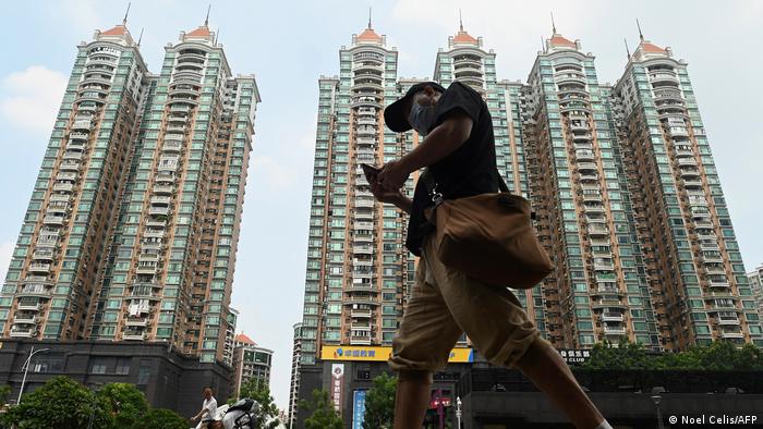 Un hombre pasa junto a un complejo de viviendas del promotor inmobiliario chino Evergrande, en Guangzhou.