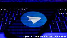 Telegram logo displayed on a phone screen and binary code displayed on a laptop screen are seen in this illustration photo taken in Sulkowice, Poland on August 27, 2021. (Photo Illustration by Jakub Porzycki/NurPhoto)