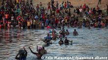 Migranten durchwaten den Rio Grande von Del Rio, Texas, nach Ciudad Acuna, Mexiko. Die USA haben Haitianer, die in der texanischen Grenzstadt kampierten, in ihr Heimatland zurückgeschickt und versucht, andere am Grenzübertritt von Mexiko aus zu hindern. +++ dpa-Bildfunk +++