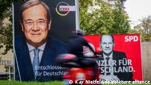 21/09/2021 Berlin, Ein Rollerfahrer fährt am Morgen an großflächigen Wahlplakaten mit den Kanzlerkandidaten von SPD mit Olaf Scholz (r), und CDU mit Armin Laschet vorbei. Am 26.09.2021 sind die Bundesbürger aufgerufen einen neuen Bundestag zu wählen. +++ dpa-Bildfunk +++