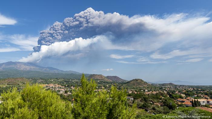 Mount Etna erupts in the background of this photo, which shows bucolic homes in Italy