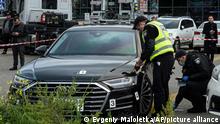 Police officers collect evidence near the car of of Serhiy Shefir, first assistant to President Volodymyr Zelenskyy, near Kyiv, Ukraine, Wednesday, Sept. 22, 2021. Ukrainian police say the car of a top aide to the country's president came under heavy gunfire, seriously wounding the driver. The national police said more than 10 bullets were fired Wednesday at the car of Serhiy Shefir, first assistant to President Volodymyr Zelenskyy. (AP Photo/Evgeniy Maloletka)