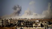 Smoke rises above a rebel-held town east of the city of Daraa during airstrikes by Syrian regime forces on June 30, 2018. - At least eight battered rebel-held towns in southern Syria returned to regime control under Russian-brokered deals after nearly two weeks of bombardment, a Britain-based monitor said. (Photo by Mohamad ABAZEED / AFP) (Photo credit should read MOHAMAD ABAZEED/AFP via Getty Images)