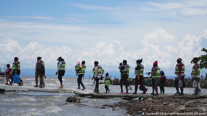 Migrantes haitianos suben a un bote para que los lleve a Acandi, en la frontera de Panamá.