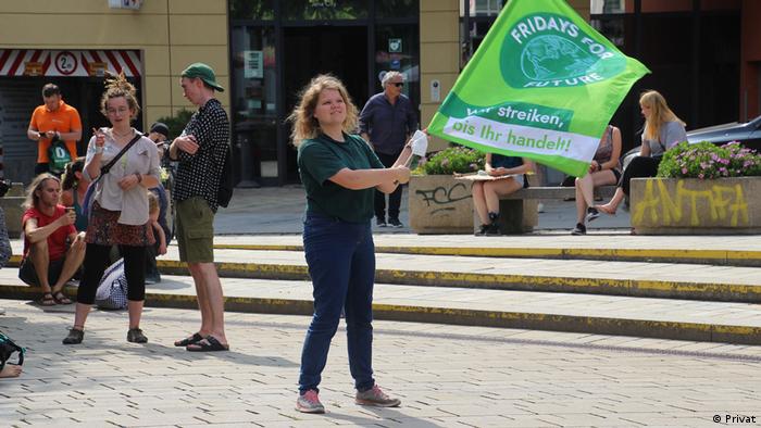 Klimaaktivistin Jana Boltersdorf schwenkt eine Fridays for Future Fahne