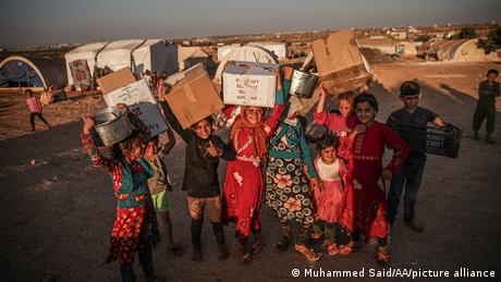 Children in Syria collect humanitarian aid at the Bab Al-Hawa border crossing