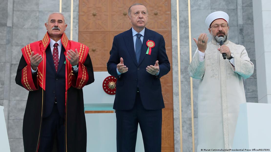 Ali Erbaş, 2021'deki adlı yıl açılışında. Cübbesiyle dönemin Yargıtay Başkanı Mehmet Akarca ve Cumhurbaşkanı Recep Tayyip Erdoğan 