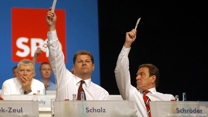 SPD-Parteitag 2003: Generalsekretär Olaf Scholz und Bundeskanzler Gerhard Schröder sitzen auf einem außerordentlichen Bundesparteitags in Berlin auf dem Podium und halten ihre Stimmkarten hoch