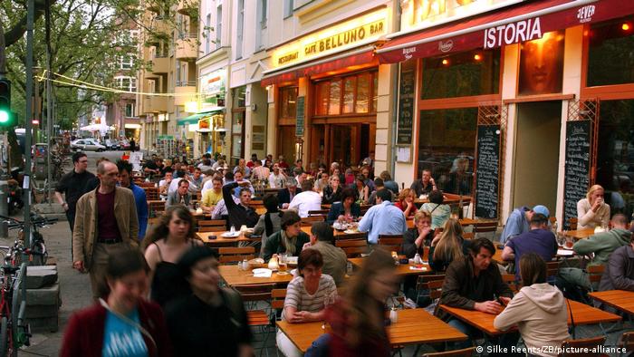 people sit outside next to each other in a bar in Germany