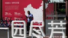 A security guard walks by a map showing Evergrande development projects in China at an Evergrande new housing development in Beijing, Wednesday, Sept. 22, 2021. The Chinese real estate developer whose struggle to avoid defaulting on billions of dollars of debt has rattled global markets announced Wednesday it will make a closely watched interest payment due this week, while the government was silent on whether it might intervene. (AP Photo/Andy Wong)
