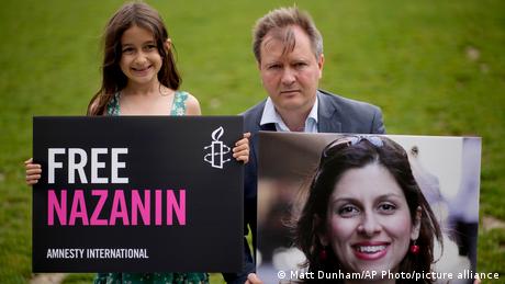 Richard Ratcliffe, the husband of imprisoned British-Iranian Nazanin Zaghari-Ratcliffe and their seven year old daughter Gabriella pose with a picture of wife and mother, Nazanin Zaghari-Ratcliffe
