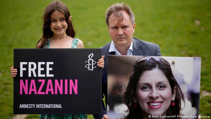 Richard Ratcliffe, the husband of imprisoned British-Iranian Nazanin Zaghari-Ratcliffe and their seven year old daughter Gabriella pose for the media backdropped by the scaffolded Houses of Parliament and the Elizabeth Tower, known as Big Ben