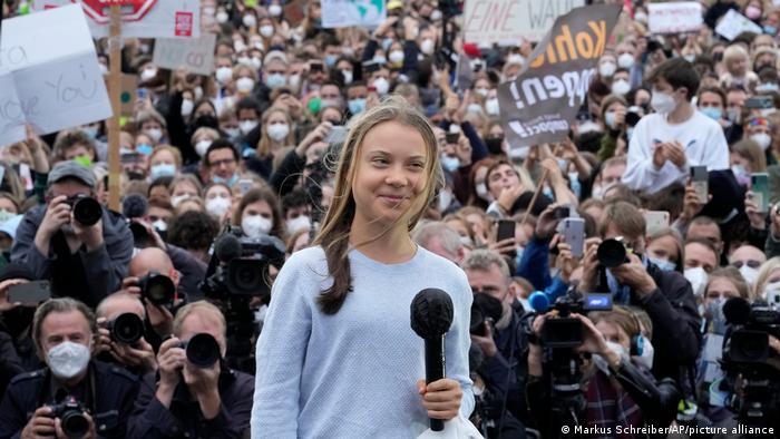Greta Thunberg holds a microphone at a demo