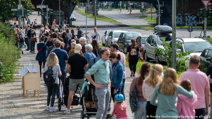 A line of people stand waiting to vote in Berlin