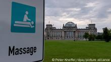 Ein Schild mit der Aufschrift „Massage“, das noch vom vergangenen Stadtmarathon stehen geblieben ist, steht vor dem Reichstag.