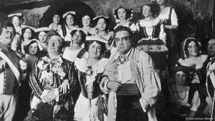 Black-and-white photo filled with opera performers including Enrico Caruso.