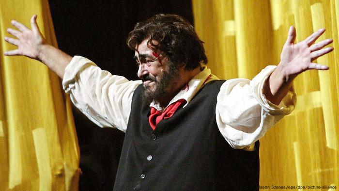  Luciano Pavarotti stretching out his arms on stage at his farewell performance