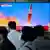 Люди в Південній Кореї дивляться у теленовинах сюжет про запуск ракети у КНДР