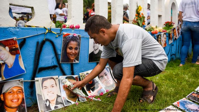 A imagem mostra um homem prestando homenagem às vítimas que morreram no desastre da barragem de 2019 na cidade de Brumadinho, estado de Minas Gerais, Brasil.