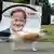 Auf einer Wiese am Straßenrand steht schräg und angerissen ein Wahlplakat der CDU mit dem Porträt von Armin Laschet
