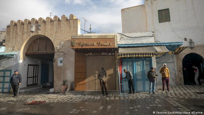 Men stand in front of closed stores as all tradesmen went on a strike on the call of the Tunisian General Workers Union.