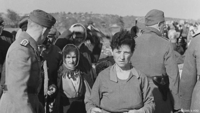 A still from Babi Yar: A black and white shot from the film shows several women and men in uniform.