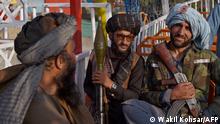 In this photograph taken on September 28, 2021 Taliban fighters enjoy a ride on a pirate ship attraction in a fairground at Qargha Lake on the outskirts of Kabul. - This is Afghanistan! a Taliban fighter shouts on the pirate ship ride at a fairground in western Kabul, as his armed comrades cackle and whoop on board the rickety attraction. (Photo by WAKIL KOHSAR / AFP) / TO GO WITH: Afghanistan-conflict-fairground, SCENE by James EDGAR