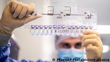 In this March 2021 photo provided by Pfizer, a technician inspects filled vials of the Pfizer-BioNTech COVID-19 vaccine at the company's facility in Puurs, Belgium. On Friday, July 9, 2021, The Associated Press reported on stories circulating online incorrectly asserting the Pfizer coronavirus vaccine is made up of 99.9% graphene oxide, a toxic compound. But, chemical and medical experts who are not associated with Pfizer confirmed to The Associated Press that there is no way graphene oxide would be found in the vaccine. (Pfizer via AP)