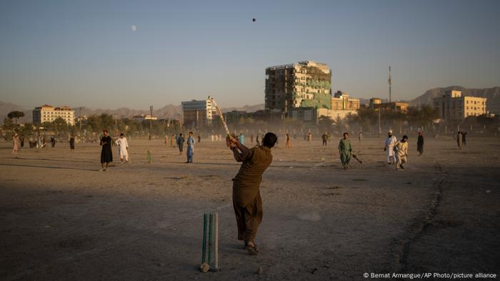 Group of young men playing cricket
