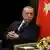 Turkish President Recep Tayyip Erdogan sits next to a Turkish flag