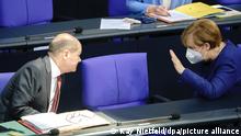 Olaf Scholz (SPD), Bundesminister der Finanzen, und Bundeskanzlerin Angela Merkel (CDU) unterhalten sich bei der Sitzung im Bundestag zu Beginn der Haushaltswoche.