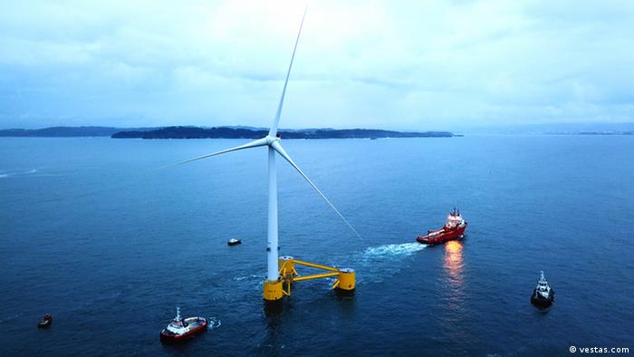 The white wind turbine is mounted on three connected buoys on the Vestas offshore wind farm 