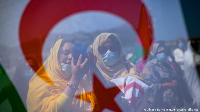 Two women seen through a Saharan flag