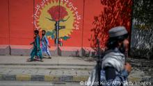TOPSHOT - A Taliban fighter walks past a mural along a street in Kabul on September 15, 2021. (Photo by BULENT KILIC / AFP) (Photo by BULENT KILIC/AFP via Getty Images)