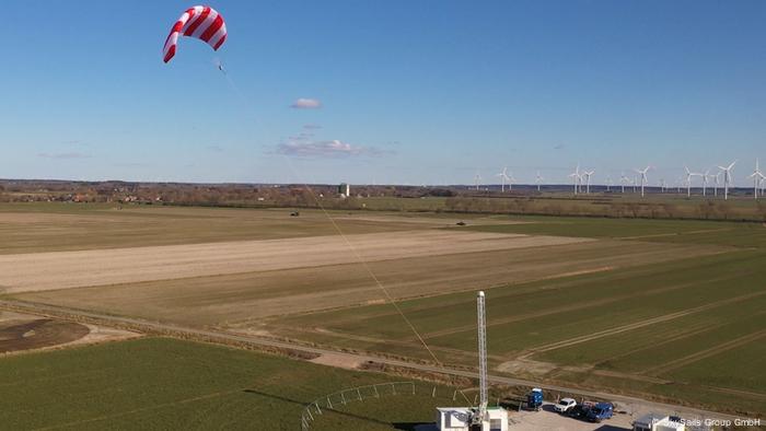 a red and white stripped kite flies in the sky