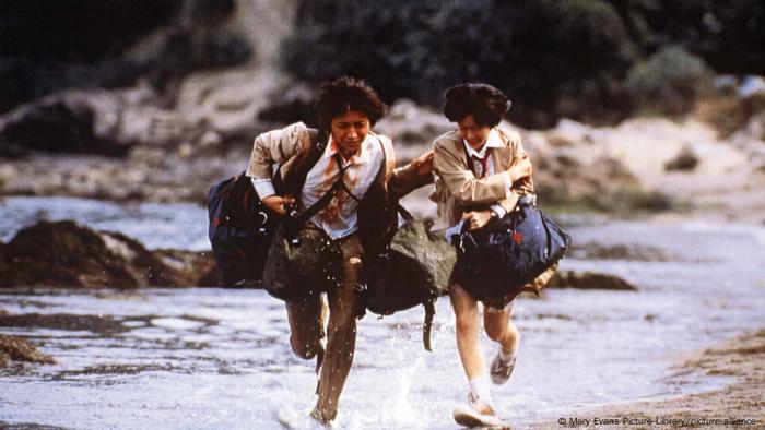 Film still from 'Battle Royale,' bloodied teenagers run through water