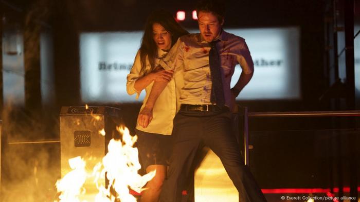 Film still 'The Belko Experiment' with a man and woman in front of a fire.