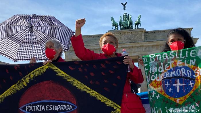 Vor dem Brandenburger Tor halten drei Frauen Plakate: Vergewaltigte Heimat, In Brasilien findet ein Völkermord statt