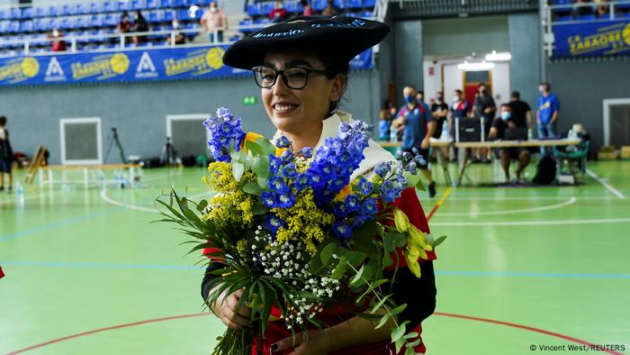 Nilofar Bayat, con un sombrero tradicional vasco, lleva flores en el campo después de su primer partido en España