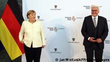 German Chancellor Angela Merkel (L) poses next to German President Frank-Walter Steinmeier prior central celebrations on the Day of German Unity at the Georg-Friedrich-Händel Halle event venue in Halle, eastern Germany on October 3, 2021, on the 31st anniversary of the German Reunification. - Germany marks 31 years since the historic unification of the communist East with the capitalist West. This year's central celebrations for the Day of German Unity take place in Halle and are accompanied by the 'EinheitsExpo' exhibition in the city center. (Photo by Jan Woitas / POOL / AFP) (Photo by JAN WOITAS/POOL/AFP via Getty Images)