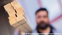 Ein Dachdecker trägt auf seiner Schulter ein Bündel mit Dachlatten. Der Baustoff Holz ist derzeit knapp. Das Handwerk in Mecklenburg-Vorpommern fordert angesichts zunehmender Materialengpässe Hilfe von der Politik. (zu dpa-lmv: «Rohstoffmangel - Handwerk will mehr Holzeinschlag im Staatswald») +++ dpa-Bildfunk +++