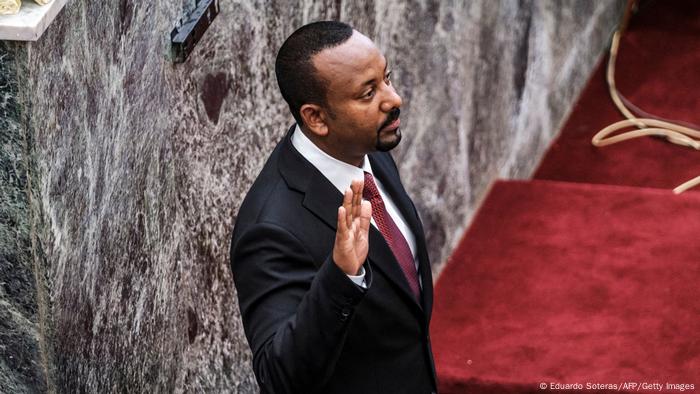 Abiy Ahmed holds up his hand as he is sworn in