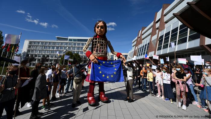 Little Amal arrives in Strasbourg holding an EU flag 