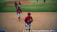 FILE - In this May 18, 2021 file photo, Cuban baseball player Cesar Prieto, front, walks on the field during a break from a training session at the Estadio Latinoamericano in Havana, Cuba. The Cuban Baseball Federation confirmed late May 26 that Prieto defected a few hours after the squad arrived in Florida to participate in a qualifying tournament for the Summer Olympics in Tokyo. (AP Photo/Ramon Espinosa, File)