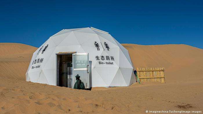 White igloo-shaped tent that reads bio toilet2 in a desert surrounding 